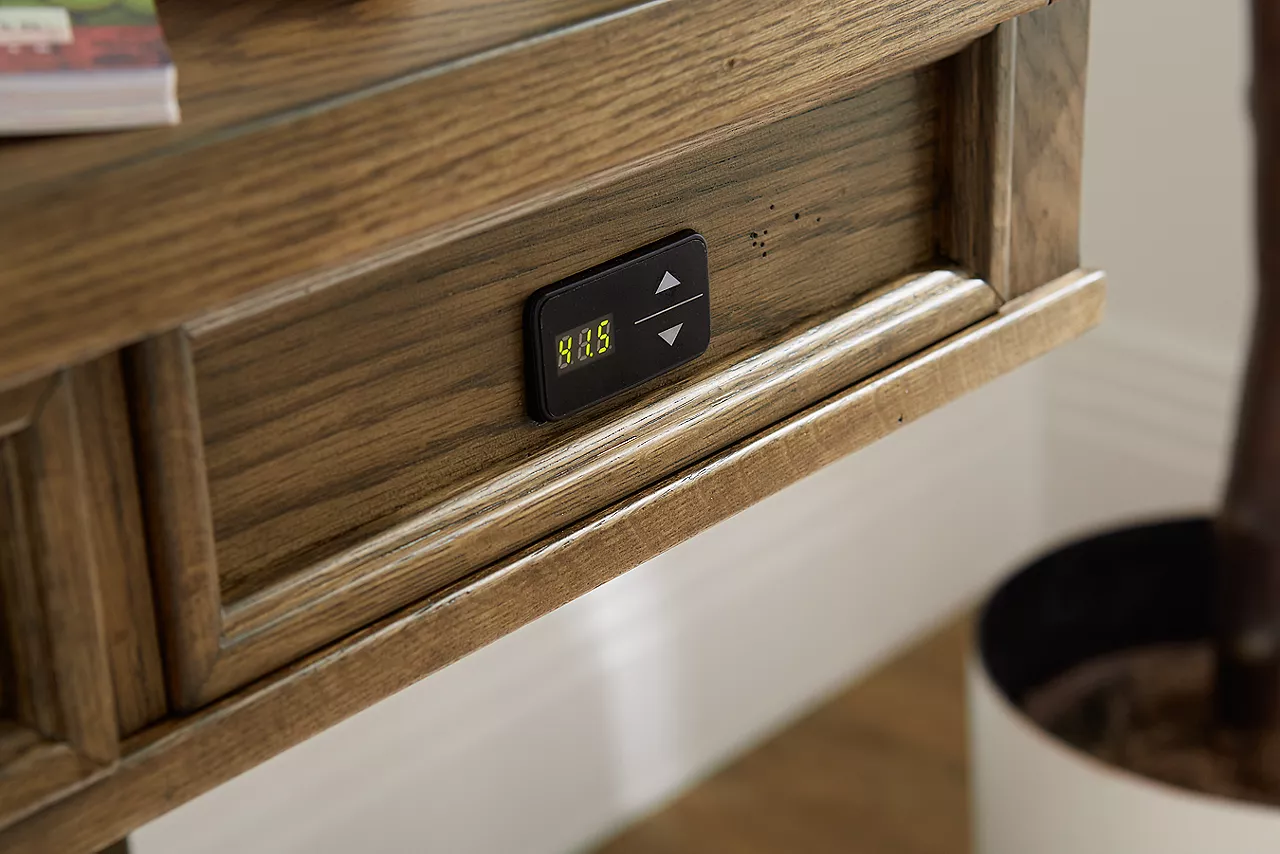 Closeup of the controls for the Avondale II Standing Desk in Vintage Oak in a room scene.
